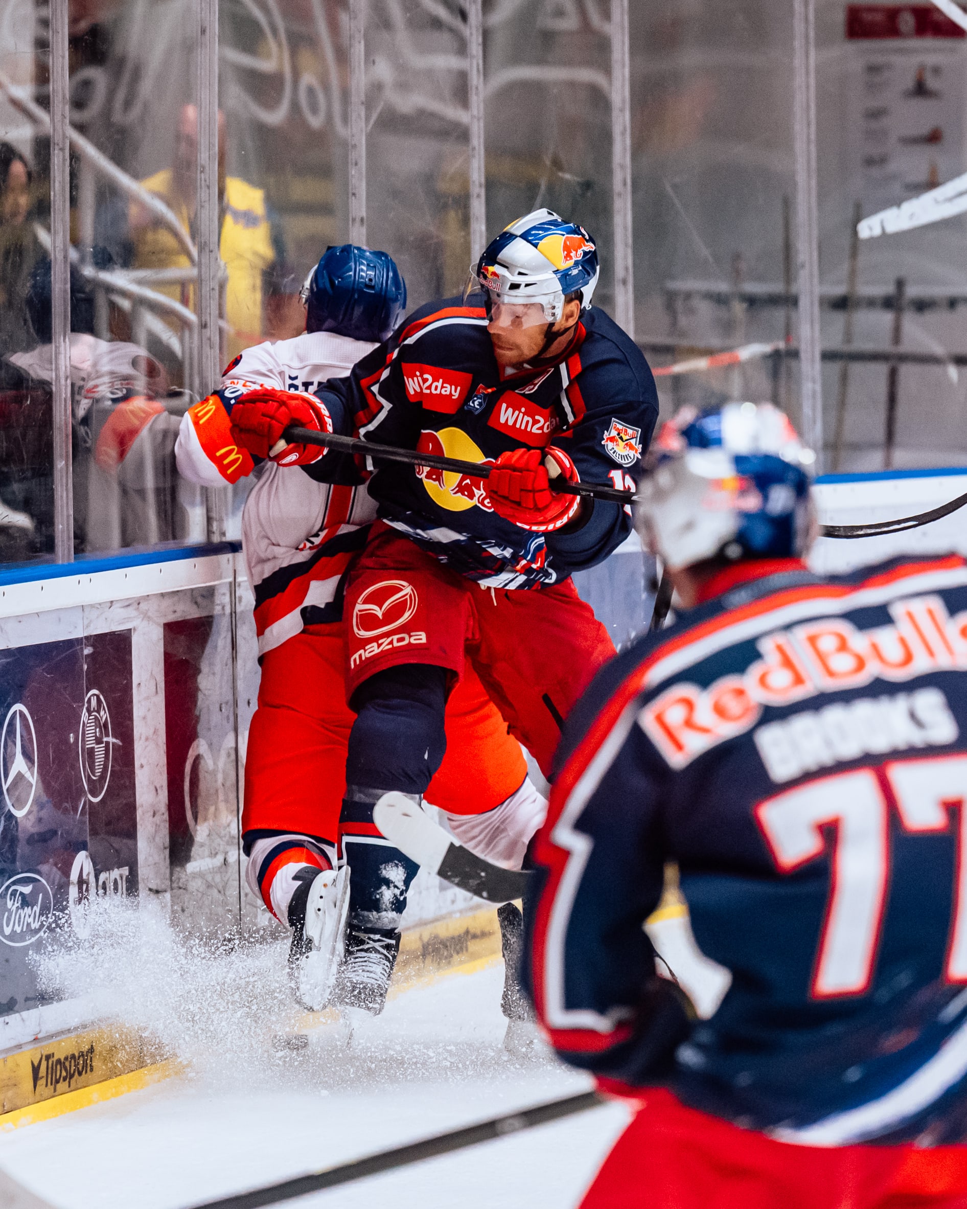 Eishockey-Spieler im Kampf um den Puck an der Bande in Salzburg