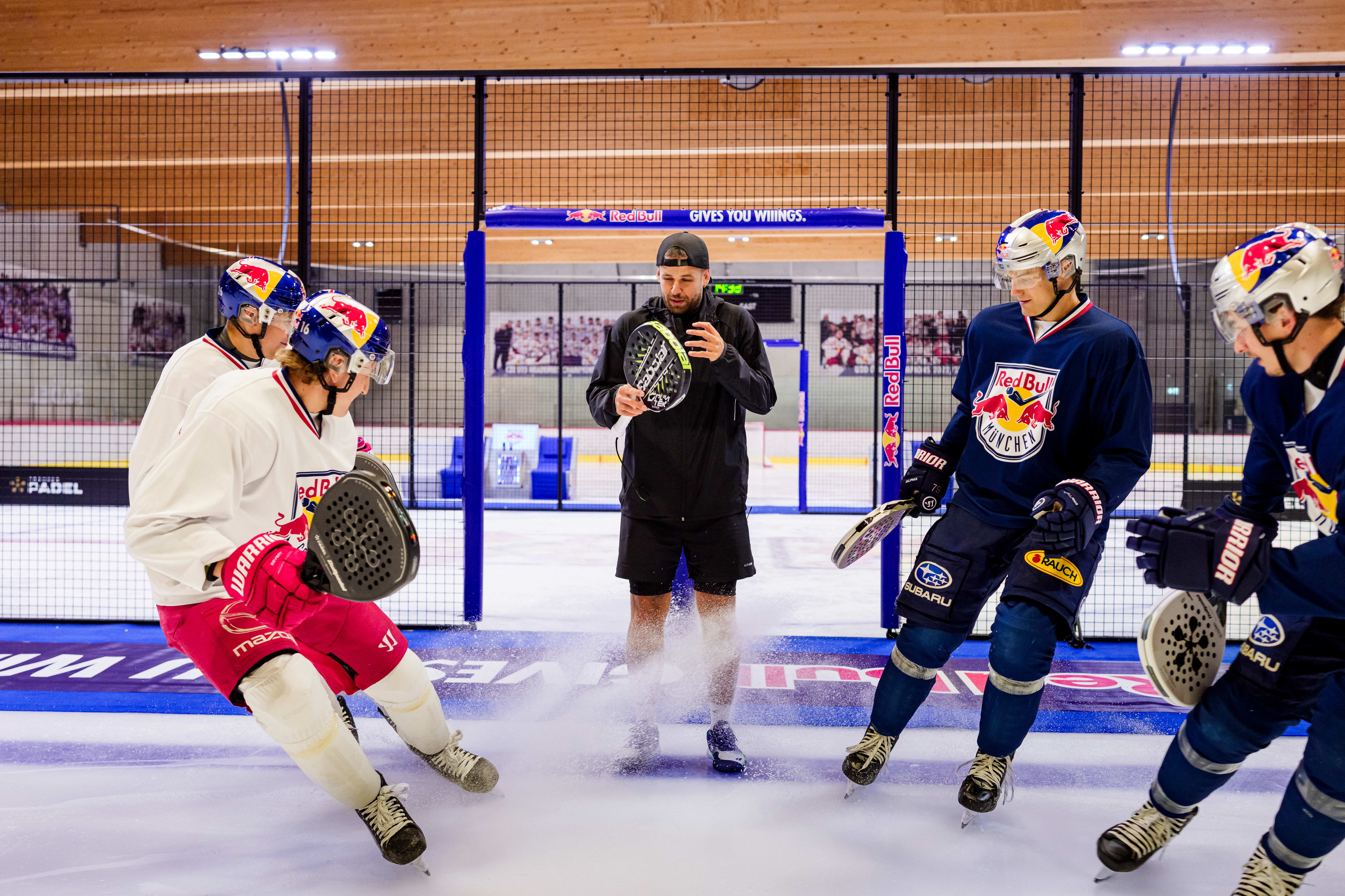 Quatre hockeyeurs en patins réunis autour d’un joueur de padel sur la piste Coldest Court installée sur la glace à Salzbourg